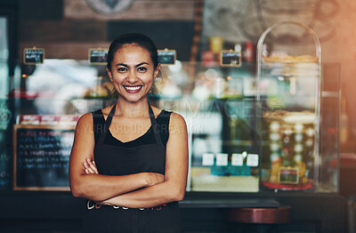 Buy stock photo Portrait of a young barista posing with her arms crossed in a coffee shot