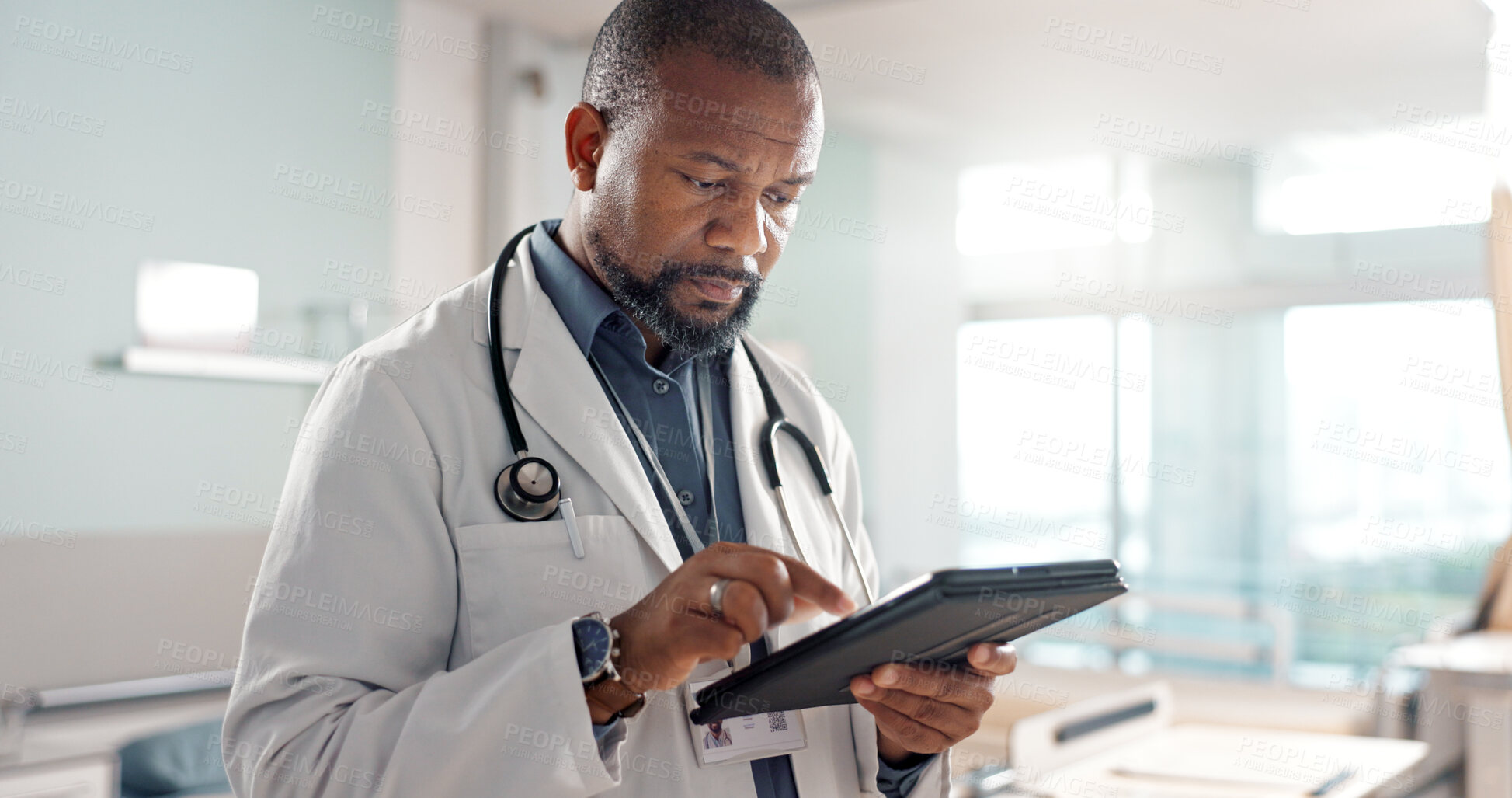 Buy stock photo Healthcare, typing and a black man or doctor with a tablet for a medical app or communication. Mature, reading email and an African surgeon with technology for results, information or surgery advice