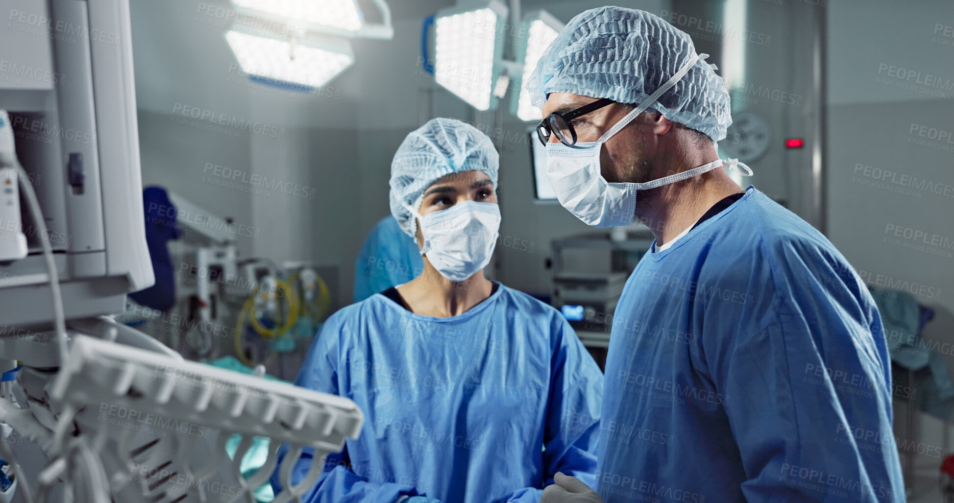 Buy stock photo Medical team, people and doctor in operating room to talk, strategy and pointing at screen for surgery. Man, woman and scrubs in healthcare with equipment in theatre with monitor for xray of patient