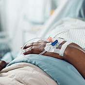 Patient hand, bed and drip in closeup, hospital or treatment ...