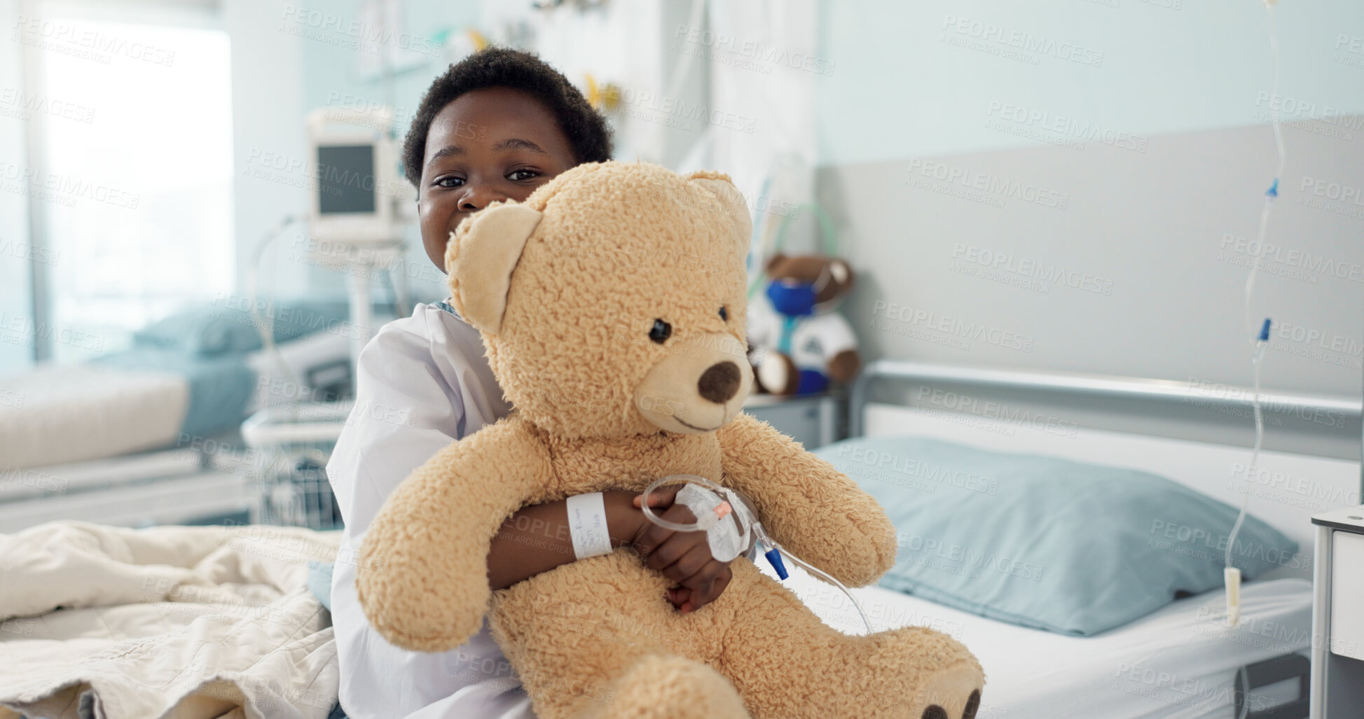Buy stock photo African boy child, hospital and teddy bear on bed with face, smile and rest for recovery for healthcare treatment. Patient kid, happy and portrait to relax, clinic and hug with toys after surgery