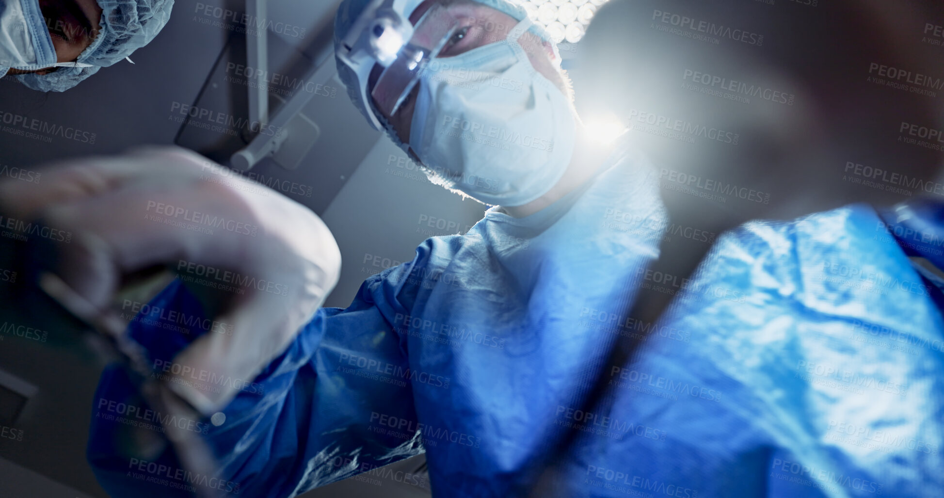 Buy stock photo Team, doctors and below in surgery, operation theater and healthcare clinic. Group, surgeon and medical tools for collaboration in emergency room, treatment of people and hands working on lens flare