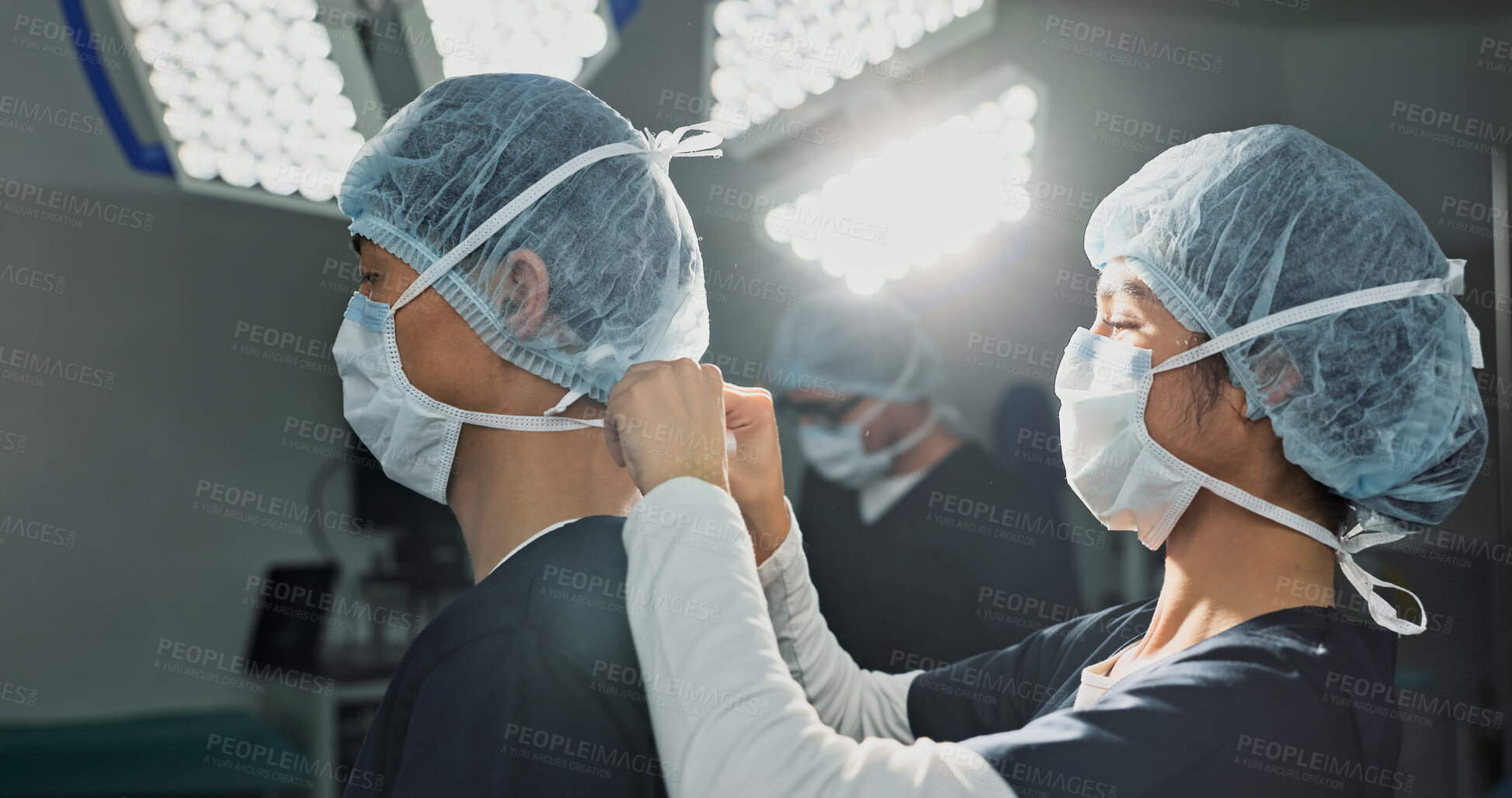 Buy stock photo Surgery, hospital and doctors tie mask in operating room for medical service, preparation and operation. Healthcare team, safety scrubs and people with uniform for emergency, procedure and protection