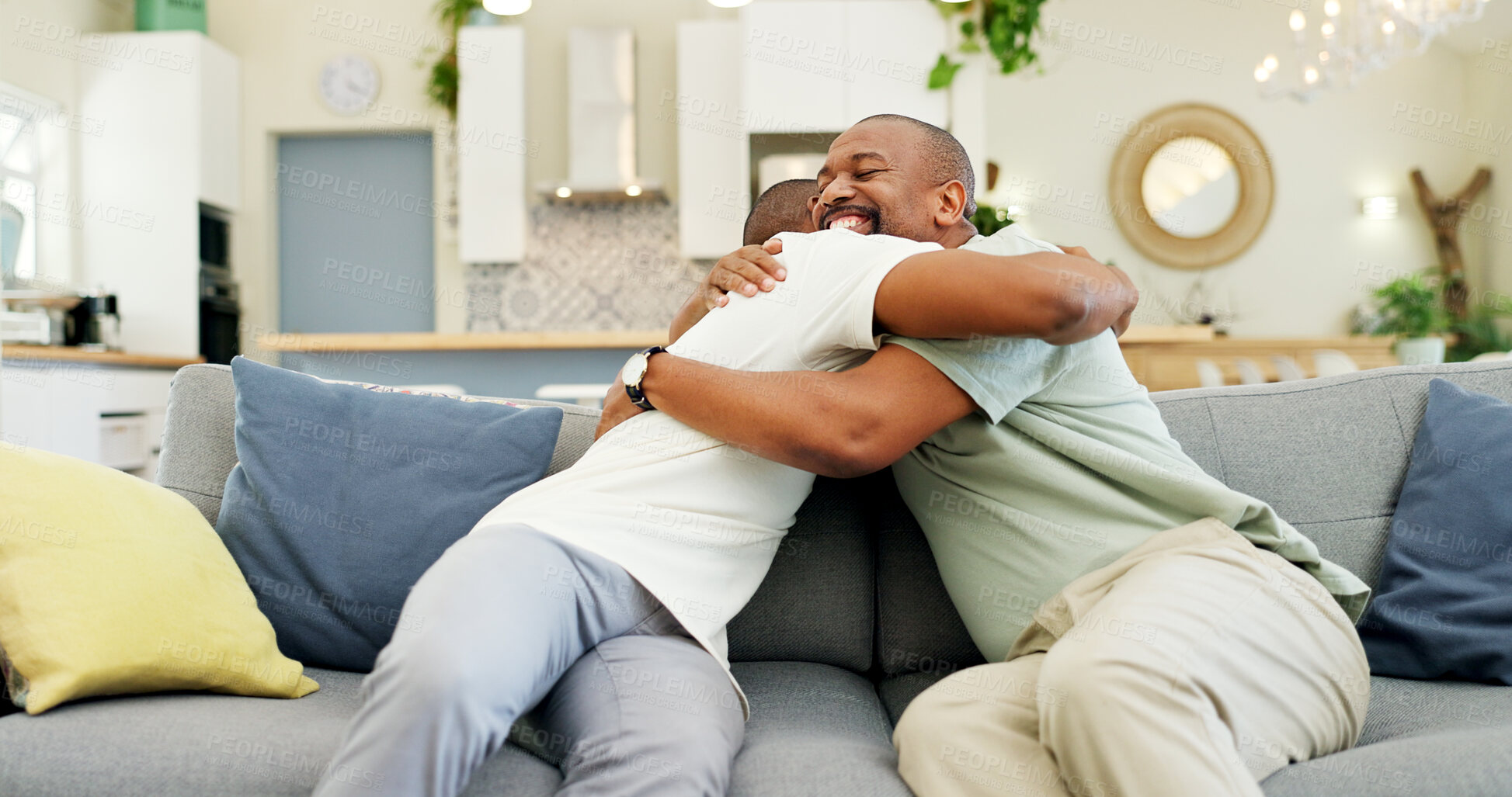 Buy stock photo Hug, talking and a father and son on the sofa for a visit, bonding or gratitude. Happy, house and an African dad embracing an adult man for greeting, love or care during a conversation on the couch