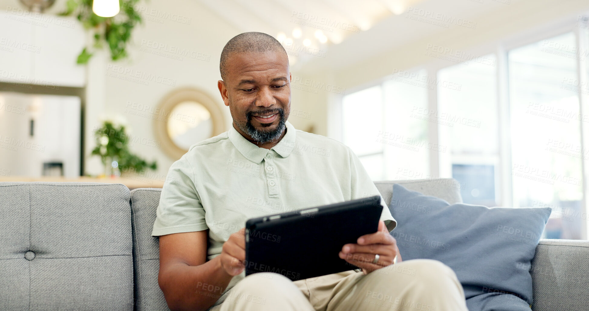 Buy stock photo Technology, mature man with tablet and in living room of his home happy for social media. Online communication or networking, connectivity or leisure and black male person on couch with smile