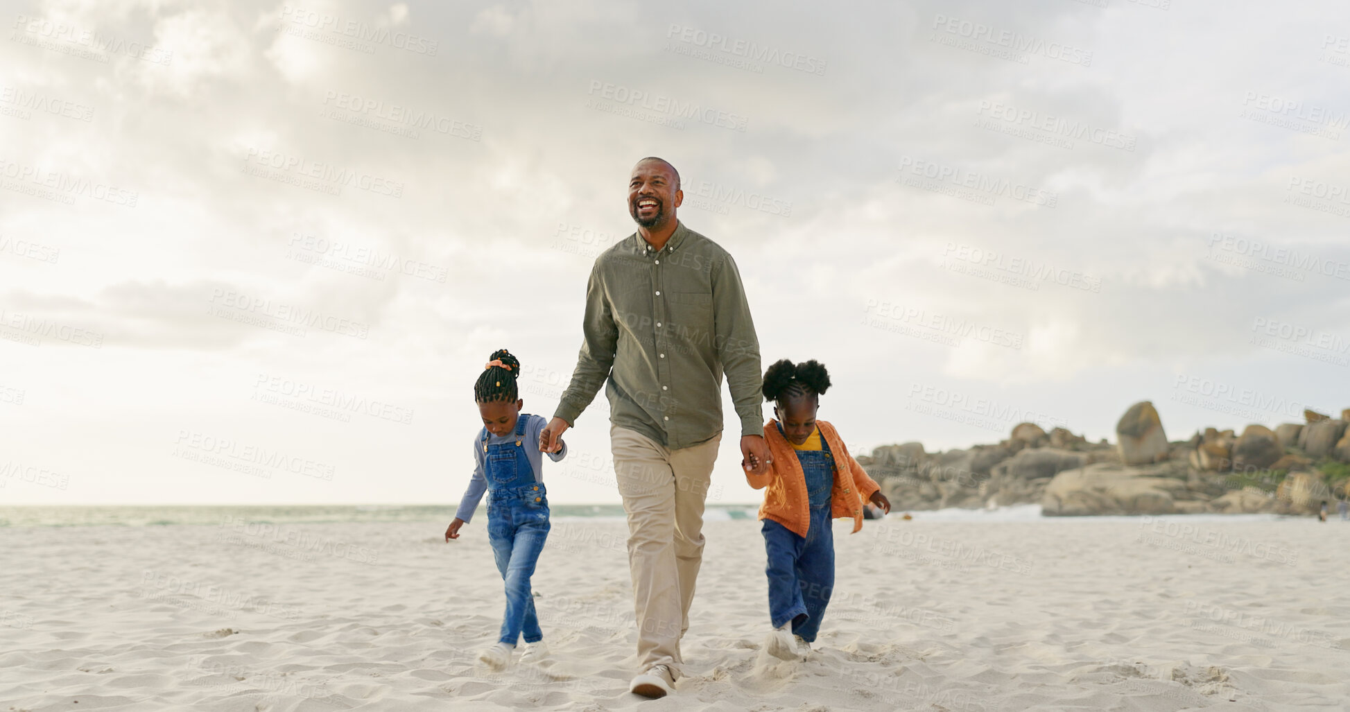 Buy stock photo Walking, father and children holding hands at the beach for bonding, summer freedom and care. Happy, family and an African dad with affection for kids on a walk in the sand at the ocean on holiday