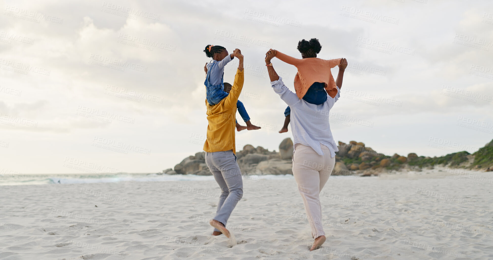 Buy stock photo Kids on parents shoulders at beach and back view, travel and playful, freedom outdoor with love and bonding. Carefree, energy and holiday with people in nature, mom and dad with kids and family