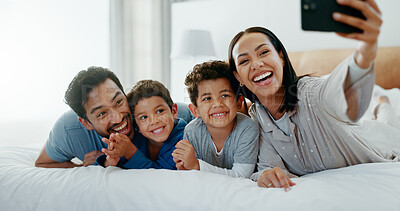 Family selfie, laughing and in a home bedroom for a memory, happy and comedy together. Smile, love and a young mother, father and children taking a photo on a bed in the morning for care and fun