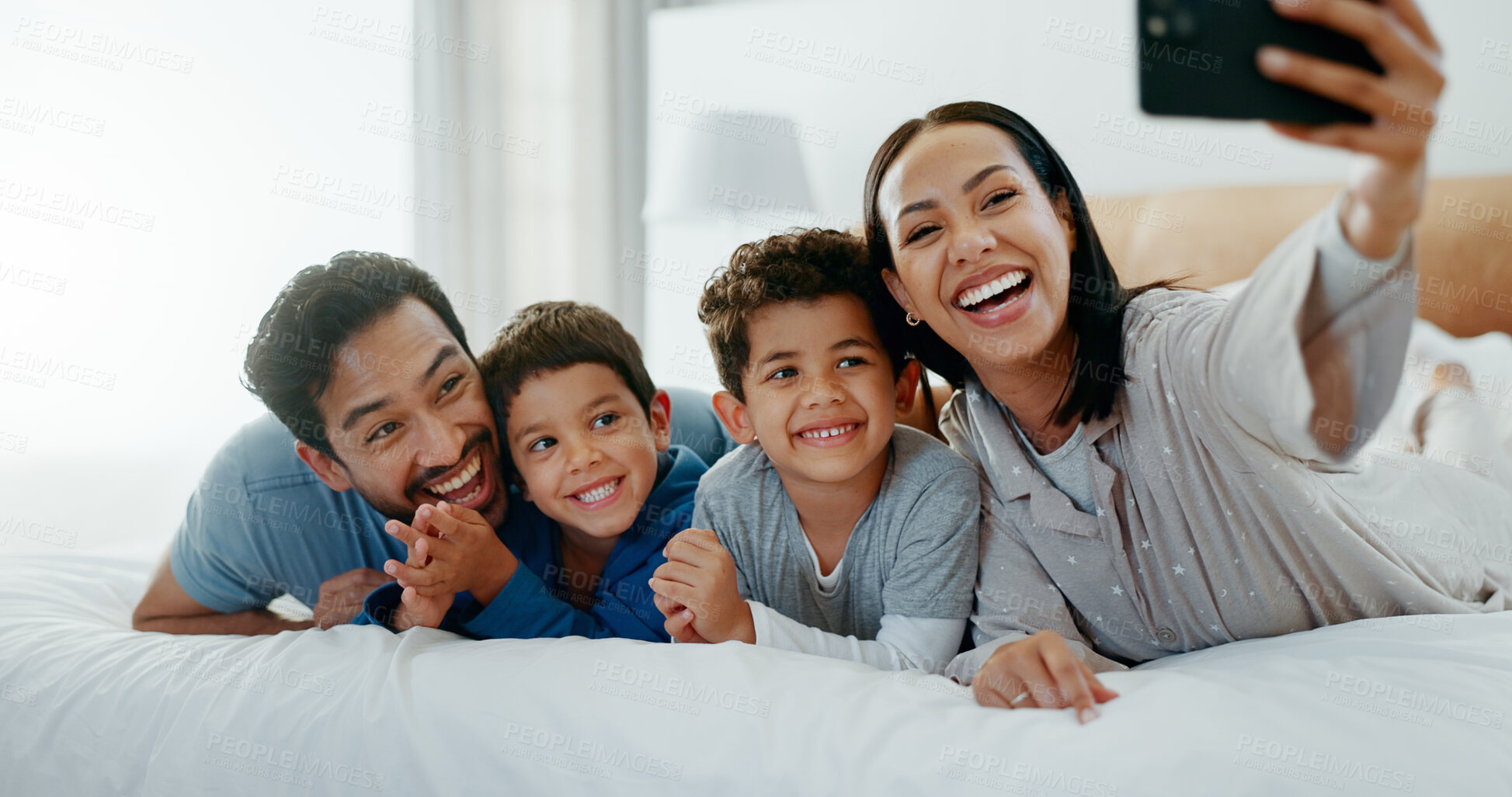 Buy stock photo Family selfie, laughing and in a home bedroom for a memory, happy and comedy together. Smile, love and a young mother, father and children taking a photo on a bed in the morning for care and fun