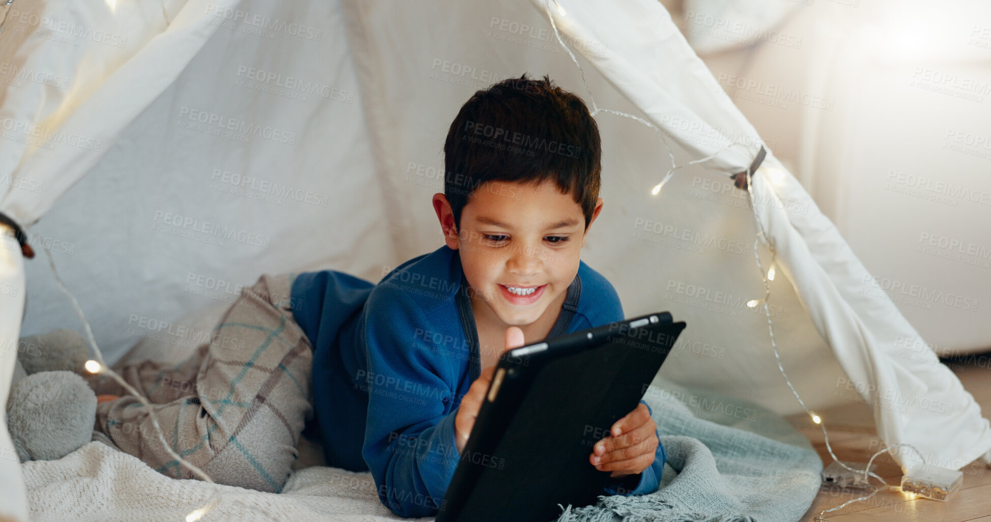 Buy stock photo Tablet, relax and boy child in a tent playing an online game on the internet in the living room. Happy, entertainment and kid watching a movie, video or show on a digital technology in a blanket fort