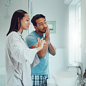 Couple, bathroom and cleaning face with cream, skincare and comic joke ...