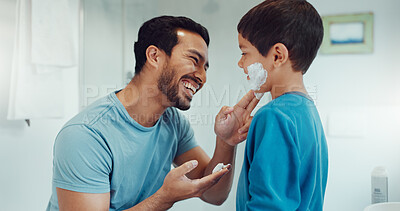 Father, child and learning with shaving cream or teaching a boy a skincare, morning beauty routine and grooming in the bathroom. Shave together, son and dad helping with foam, razor and skin care