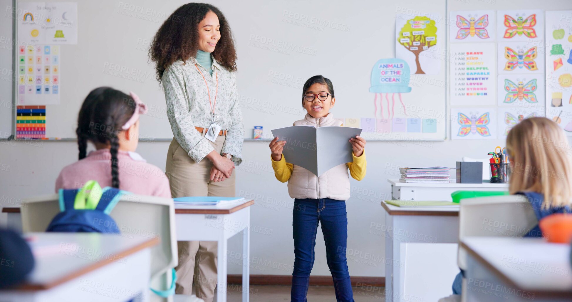 Buy stock photo Student, child and reading a book in class for learning, development and communication. A boy kid and teacher woman teaching language, support and assessment in elementary classroom at school