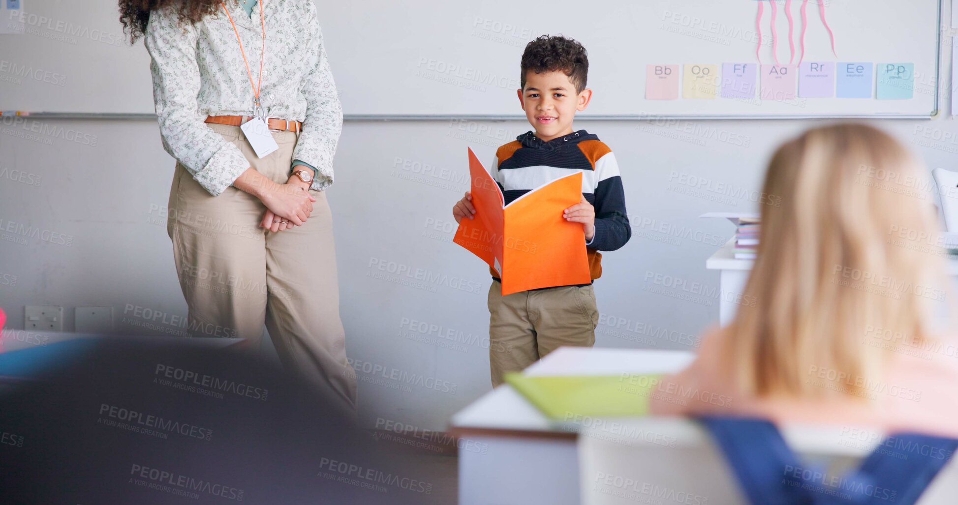 Buy stock photo Child, student and reading a book in class for learning, development and communication. Boy kid and woman teacher for language, support and assessment or confidence in elementary classroom at school