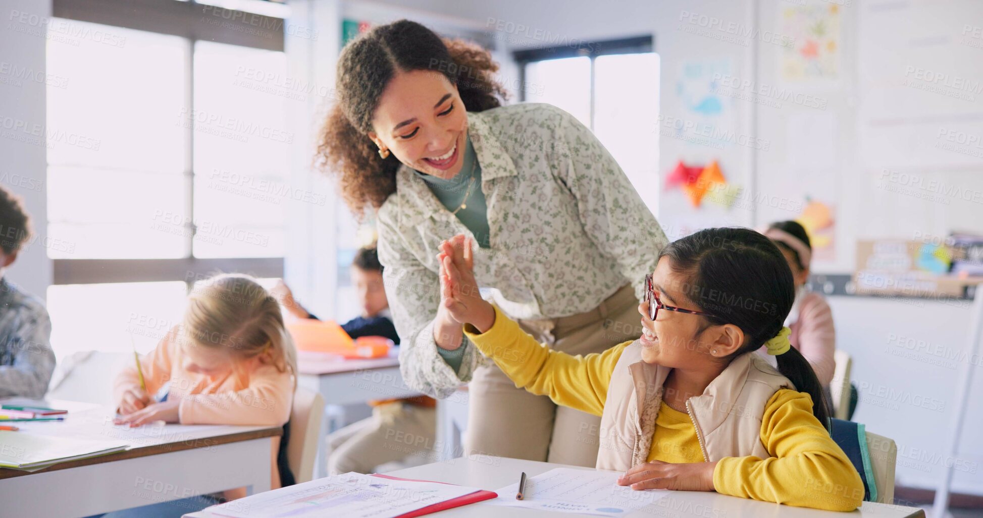 Buy stock photo Teacher woman, high five girl and classroom with achievement, success and mentorship for learning. Education, development and students with goals, knowledge and books with celebration at school desk