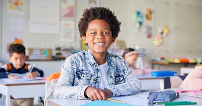 Smile, education and writing with boy in classroom for learning, knowledge and study. Scholarship, happy and future with portrait of young student at school for academy, exam test and project