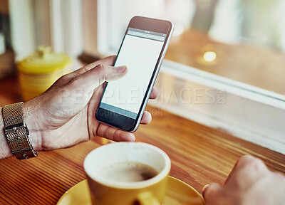 Buy stock photo Cropped closeup shot of a young man reading a text message while sitting at a counter in a cafe
