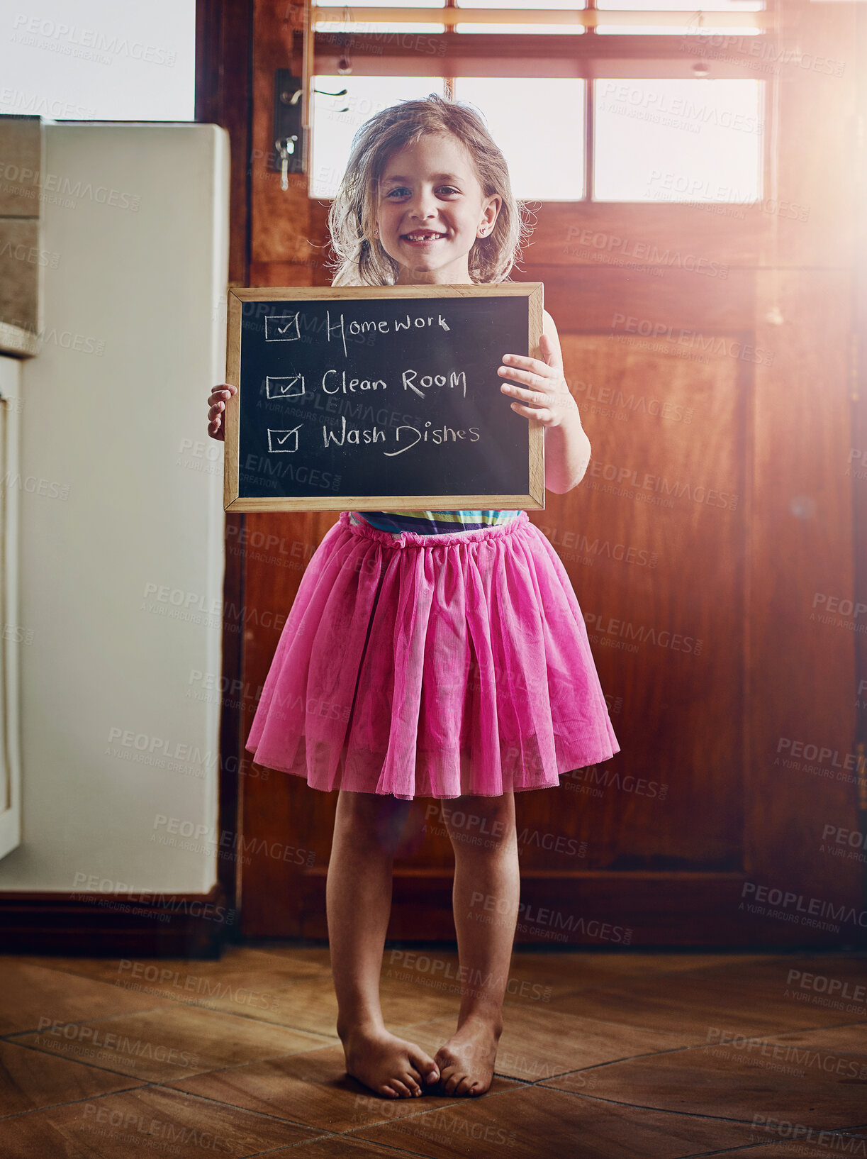 Buy stock photo Portrait of a little girl holding a chalkboard with chores written on at home