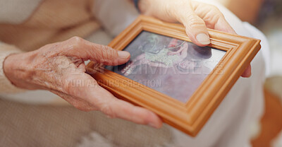 Frame, picture and hands of senior person for nostalgia, memories and thinking of past in home. Retirement home, elderly and closeup of photo to remember, mourning and depression with Alzheimer\'s