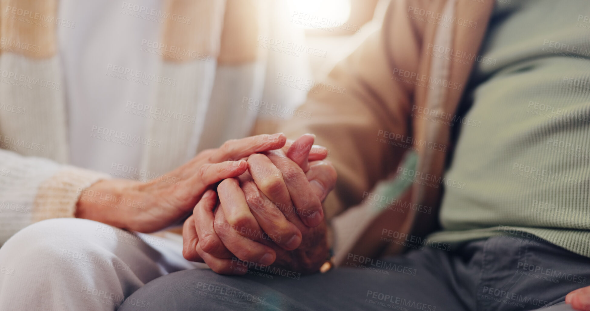 Buy stock photo Holding hands, empathy and an elderly couple closeup in their home for love, support or trust in retirement. Hope, healing or sympathy with senior people on a sofa in the living room of their home