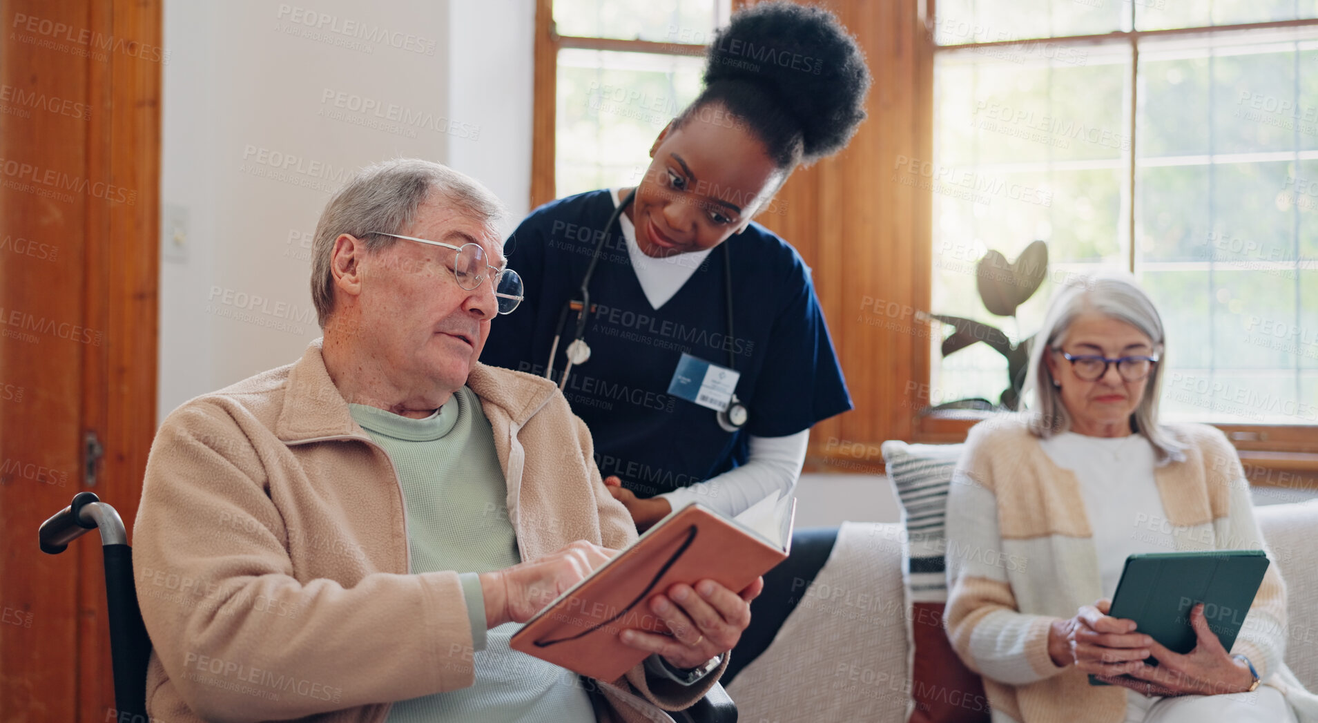 Buy stock photo Senior man, reading and nurse talking in home with book, discussion or support from nursing staff. Retirement, elderly care or person relax in conversation with caregiver in living room with notebook