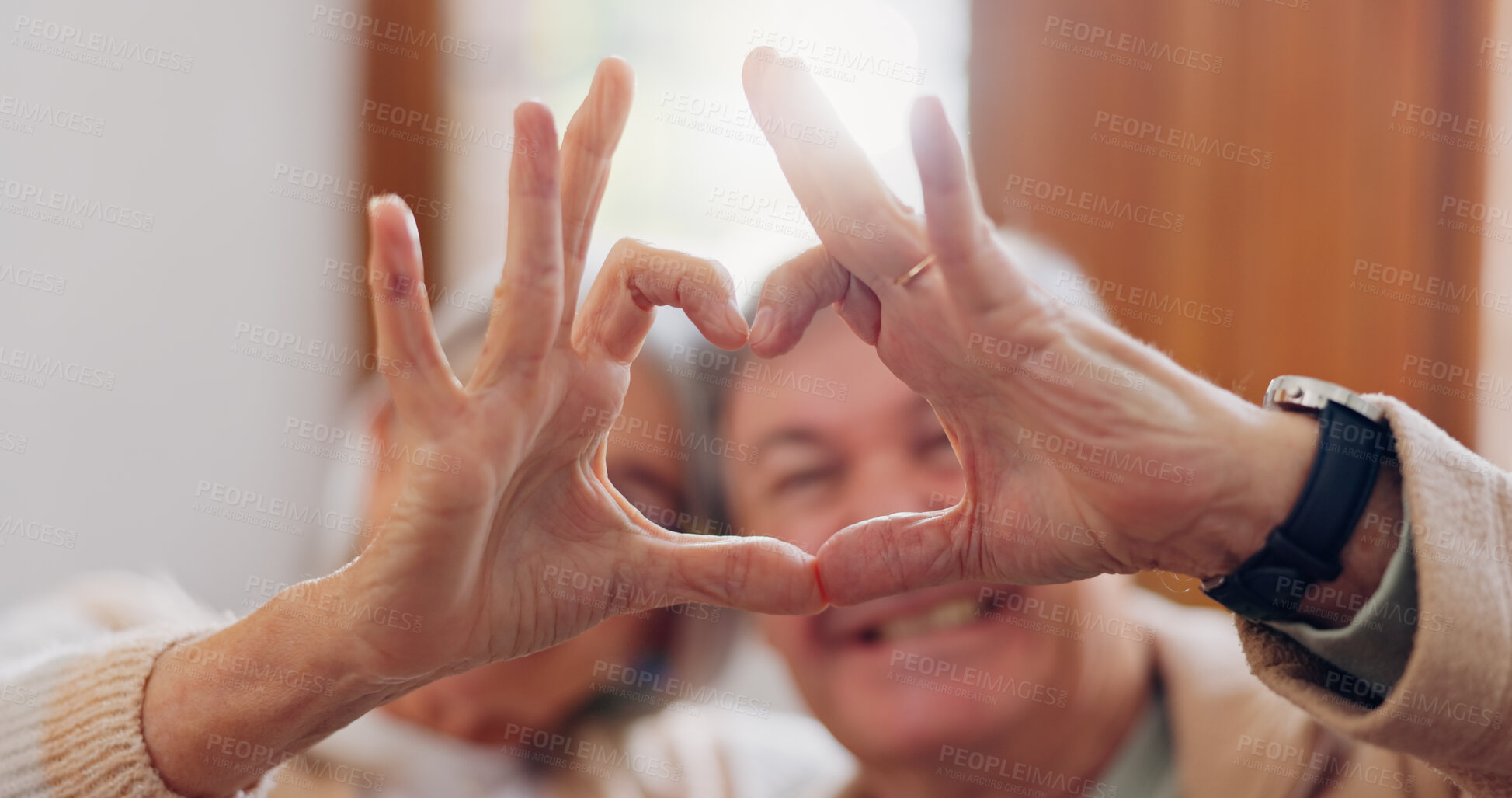 Buy stock photo Mature couple, heart hands and love on home sofa for connection, marriage and bond. A happy man and woman together on a couch with emoji, shape or symbol for commitment, trust or health and wellness