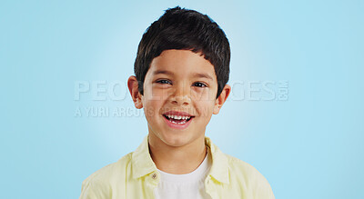 Buy stock photo Face, boy child and smile in studio for wellness and confidence on a blue background with positive mindset. Portrait, kid and happiness with casual fashion, joyful and relaxed expression on mockup