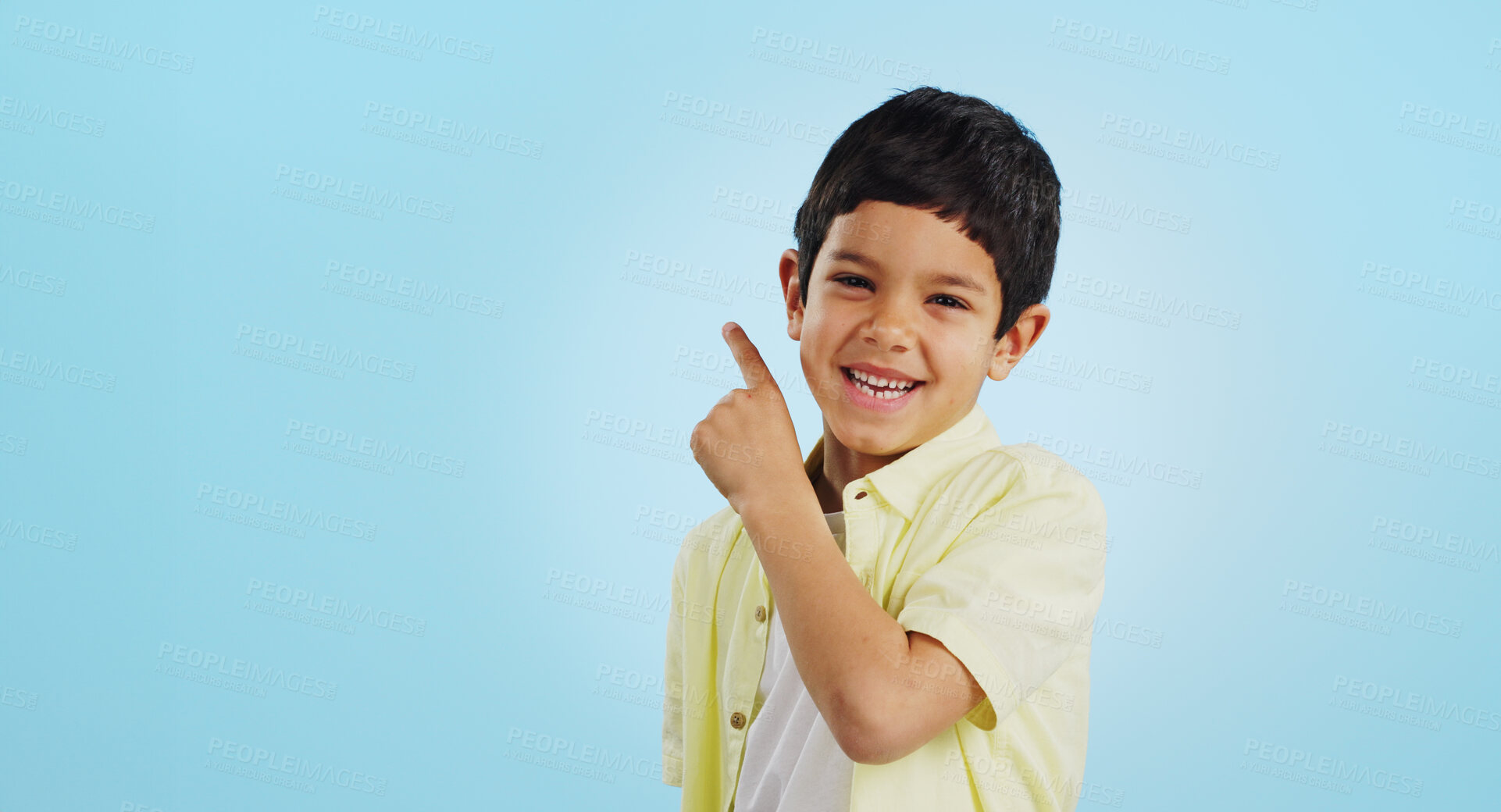 Buy stock photo Boy, smile and pointing with excitement in studio on blue background in mockup for opportunity, deal or alert. Youth, kid and happy with offer, discount or announcement on social media for consumers