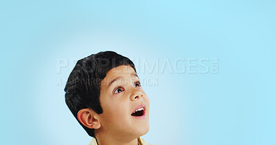 Surprise, boy and child with decision, opportunity and fantasy on a blue studio background. Person, mockup space and happy kid looking up, future and announcement with shock, expression and emoji