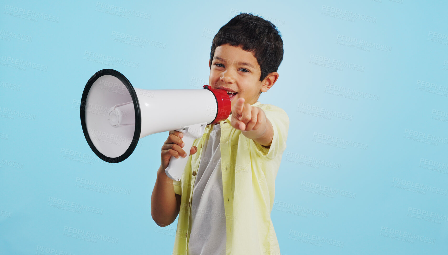 Buy stock photo Communication, face or child with megaphone for news, opinion or sale announcement on blue background. Happy, pointing or young boy talking on loudspeaker for voice, speaking or attention in studio