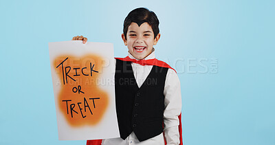 Halloween, poster and portrait of child with paper board for candy isolated in a studio blue background and happy. Holiday, laughing and kid in vampire costume for celebration in fantasy festival