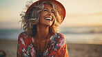 Candid shot of happy senior woman on beach during sunset. Lifestyle concept.