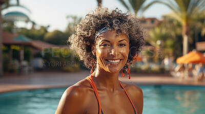 Happy senior woman posing at poolside at holiday resort. Vacation concept.