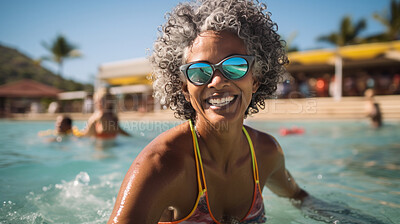 Happy senior woman in pool at holiday resort. Vacation concept.