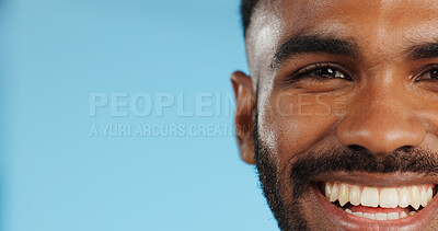 Buy stock photo Half, face and black man with smile in studio, blue background and mockup space with happiness or advertising. Portrait, closeup and marketing for skincare, wellness or healthy dermatology care