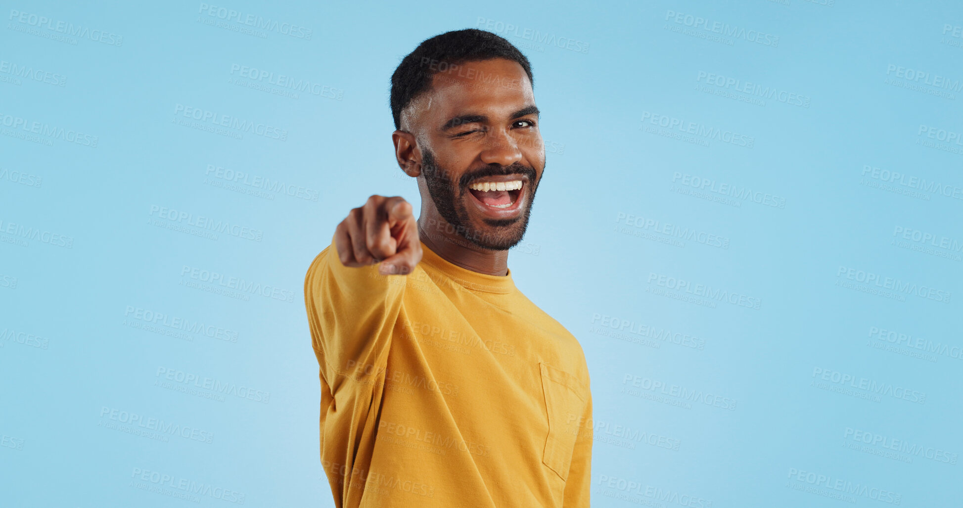 Buy stock photo Face, wink and man with hand pointing at you in studio with choice, selection or offer on blue background. Opportunity, offer and portrait of male model with emoji for join us, deal or invitation