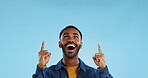 Happy man, pointing and news announcement with portrait in studio, surprise emoji and advertising. Mockup, mexican person and smiling in casual fashion for offer and notification by blue background