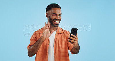 Video call, wave and man with a smartphone, showing and conversation on a blue studio background. Person, speaking and model with a cellphone, online chat and communication with network or connection