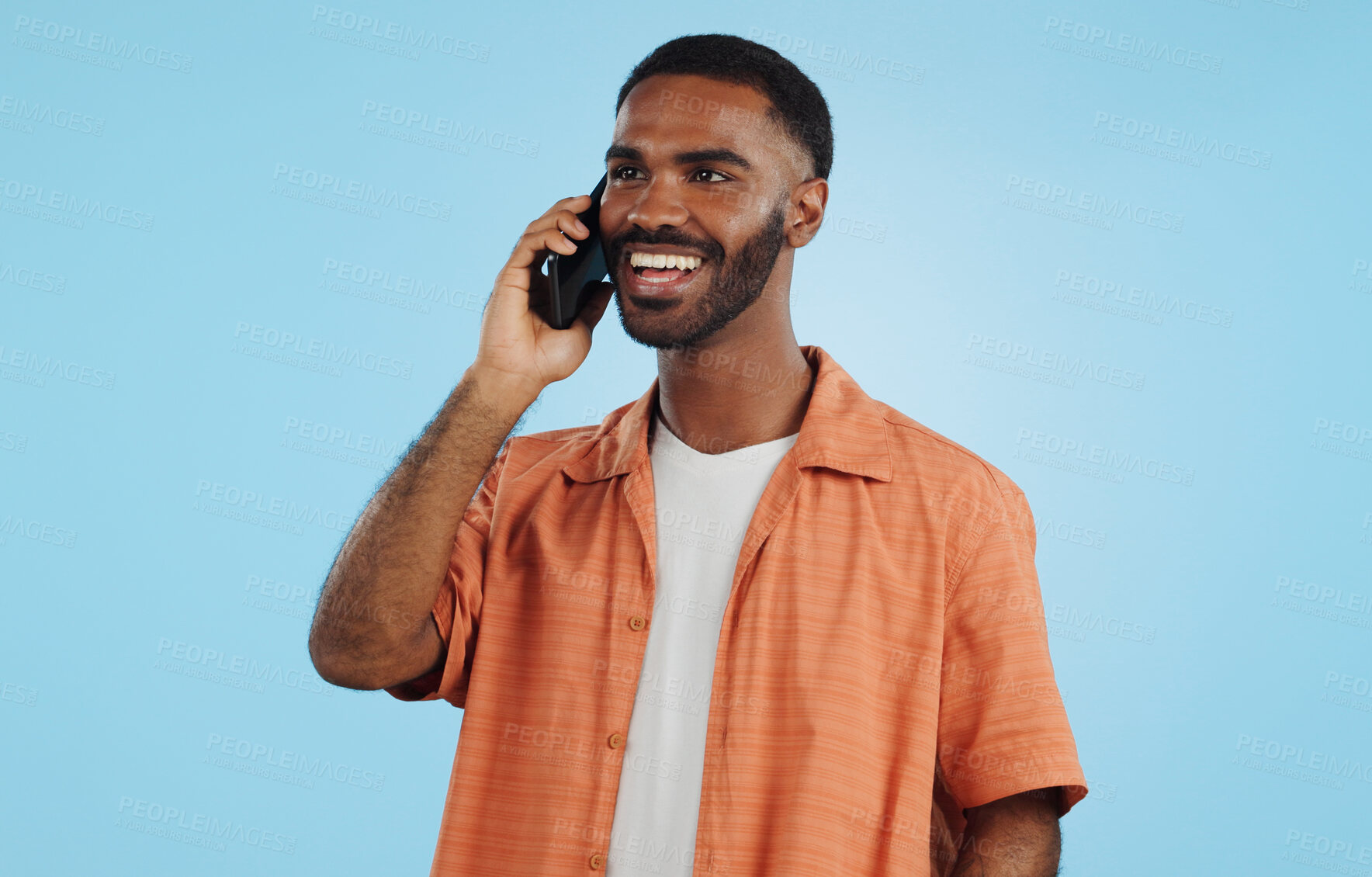 Buy stock photo Phone call, funny and black man talking, conversation and joke in studio isolated on a blue background mockup space. Smartphone, laughing and happy African person in communication, meme and comedy