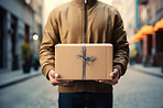 Delivery man holding packages standing in street. Delivery concept.