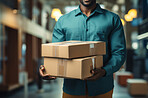 Worker holding boxes or packages in warehouse.