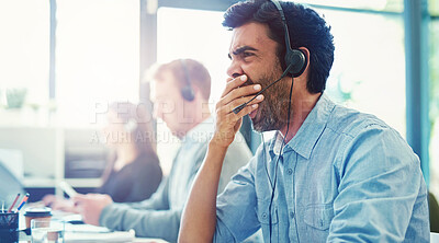 Buy stock photo Cropped shot of a call centre agent yawning while working in an office