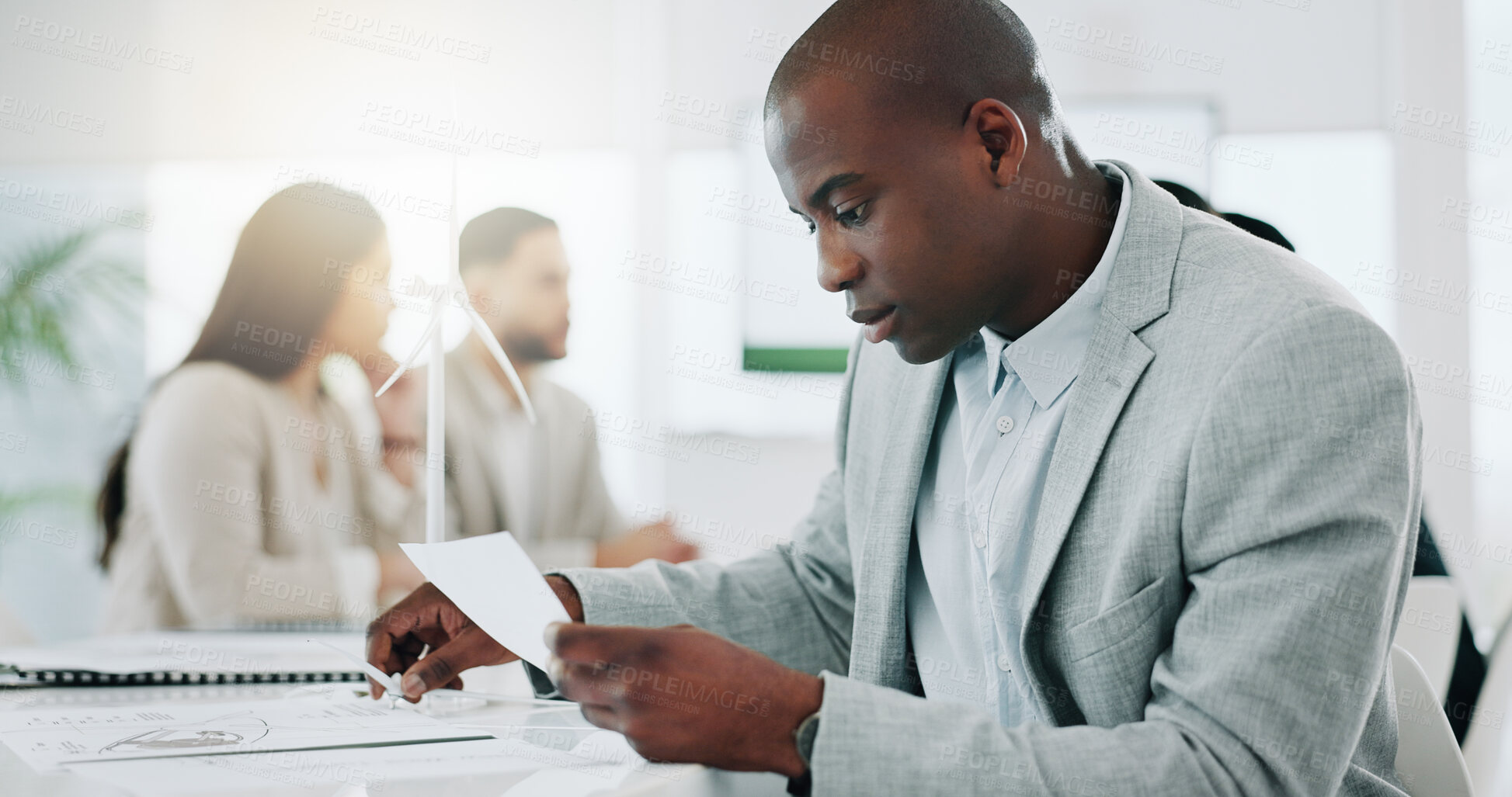 Buy stock photo Wind turbine, planning and black man in office working on clean energy and sustainability electricity. Engineering, construction project and architect with eco friendly and biodiversity design