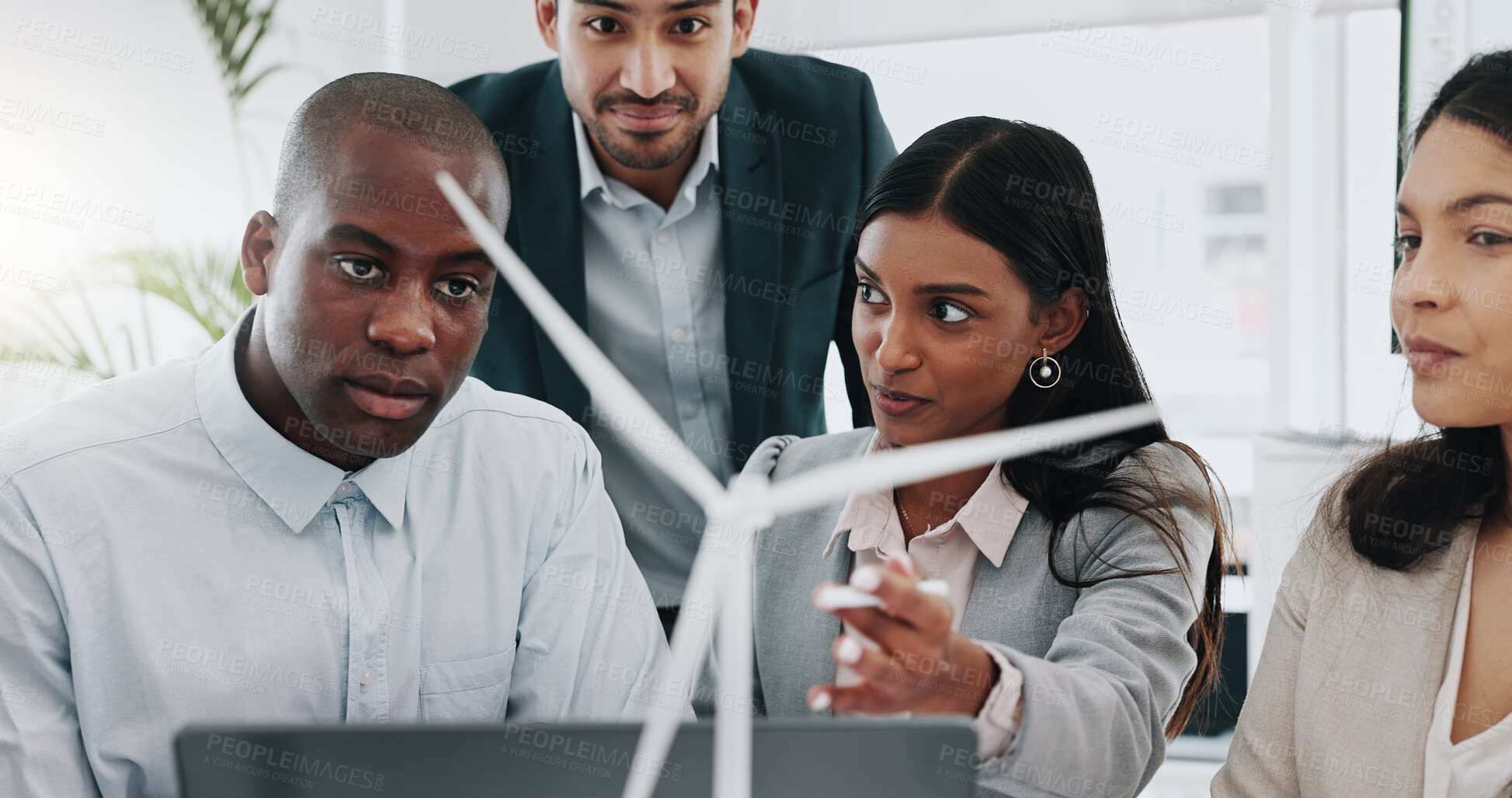 Buy stock photo Business people, windmill model and team in office, woman and laptop for innovation, energy and sustainability. Engineering consultant, group and brainstorming with wind power for clean electricity