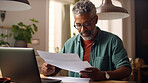 Laptop, documents and finance with a senior man busy on a budget review or pension fund