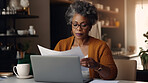 Laptop, documents and finance with a senior woman busy on a budget review or pension fund