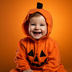 Portrait of a happy toddler wearing a pumpkin costume for halloween celebration