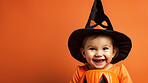 Portrait of a happy toddler wearing a pumpkin costume for halloween celebration