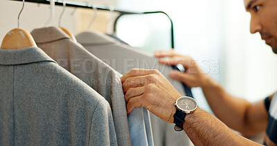 Hands of man, clothing rack or choice in store for sample, tailor or collection in small business. Creative stylist, search or designer with decision for blazer design, suit fabric or fashion clothes