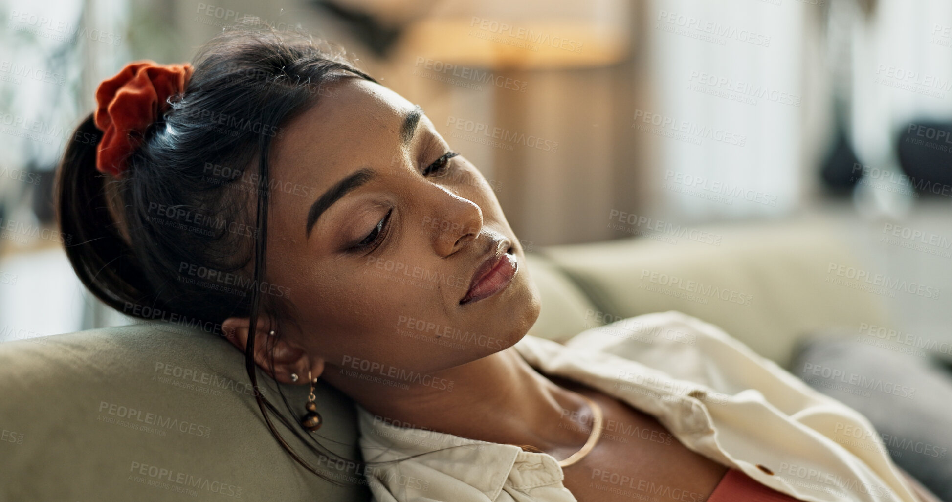 Buy stock photo Depression, sad and young woman on sofa relaxing with an idea or memory in living room. Burnout, mental health and nervous Indian female person with stress chilling in the lounge of modern apartment.